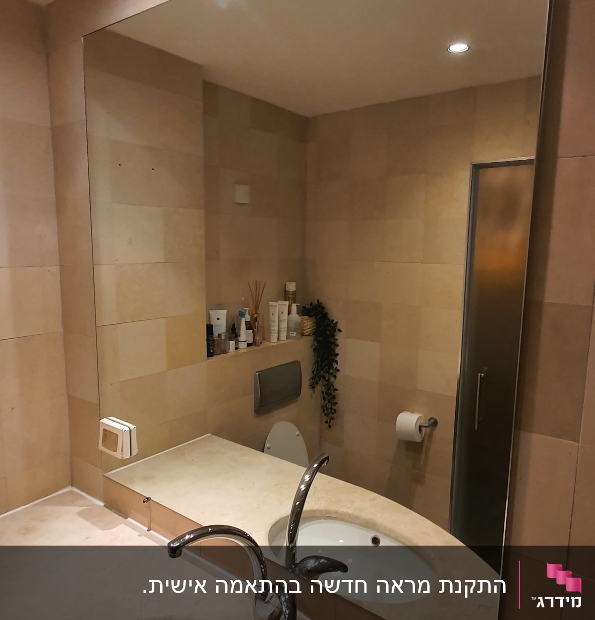 מראה גדולה מעל כיור בחדר אמבטיה